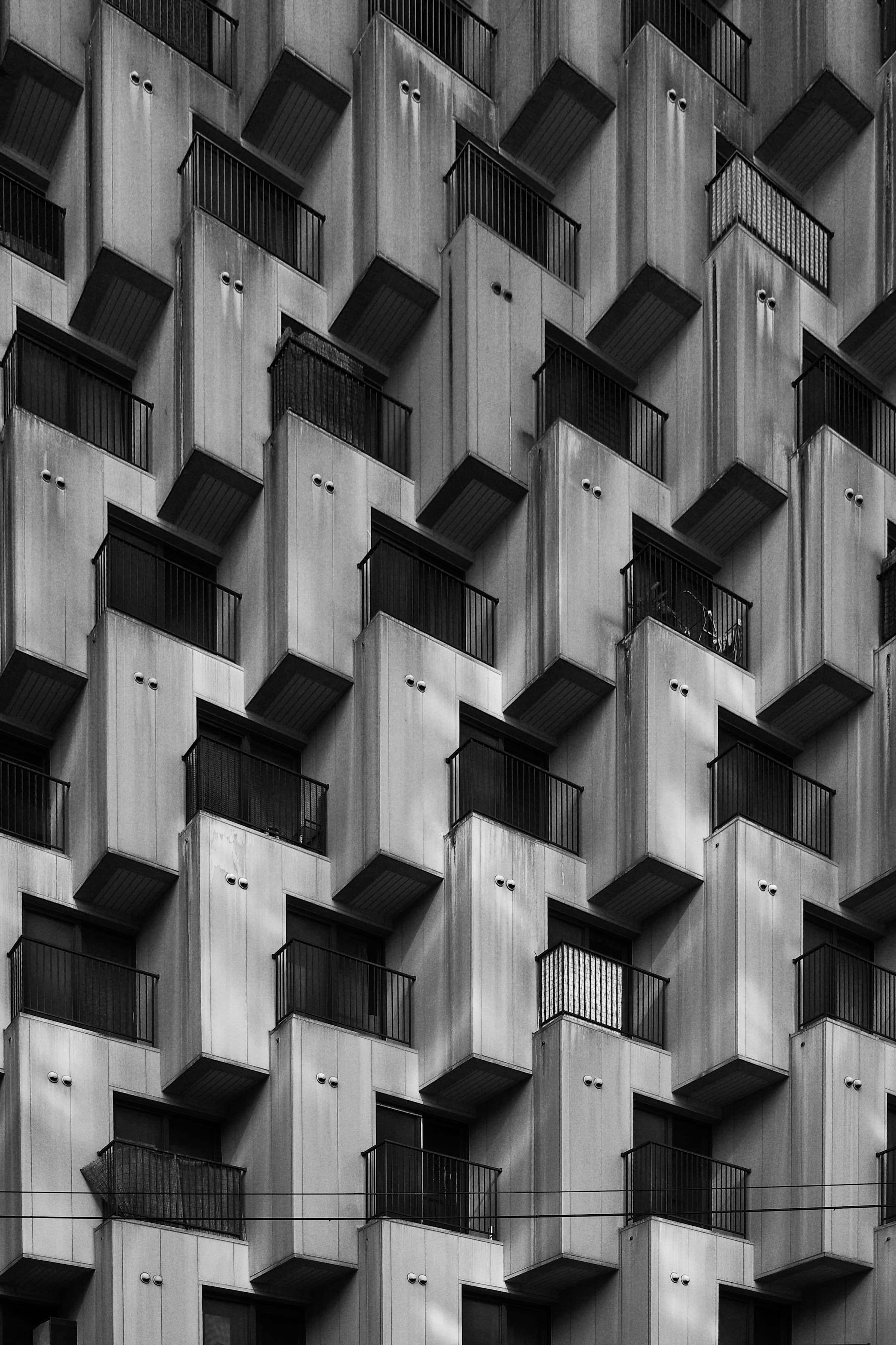 Geometrische Fassade eines modernen Wohngebäudes mit wiederkehrenden Balkonen